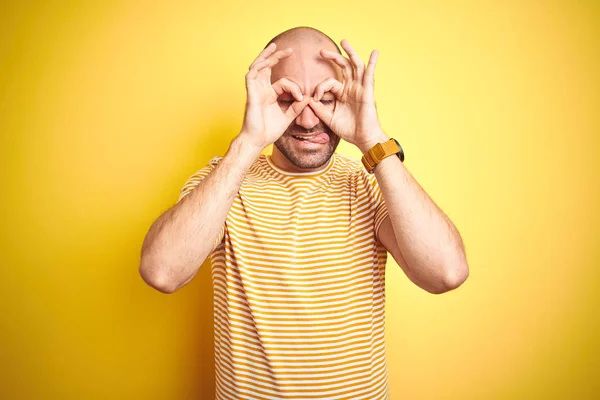 노란색 캐주얼 스트라이프 티셔츠를 수염을 대머리 남자는 내밀고 손가락을 쌍안경과 — 스톡 사진