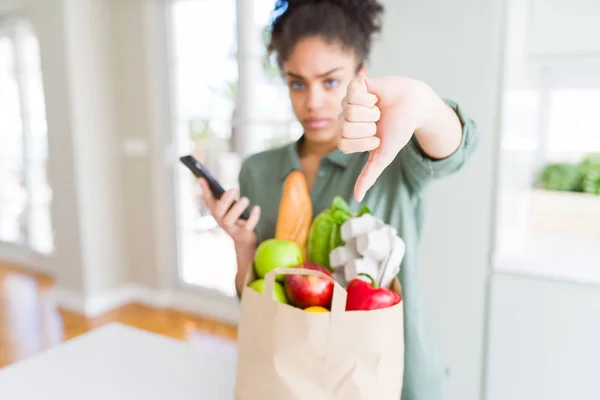 Young African American Girl Holding Paper Bag Groceries Using Smartphone — Stock Photo, Image