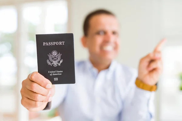 拿着美国护照的中年男子很高兴用手和手指指着旁边 — 图库照片