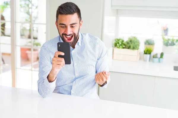 Handsome Hispanic Business Man Using Smartphone Screaming Proud Celebrating Victory — Stock Photo, Image