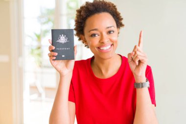 Avustralya pasaportu tutan genç Afro-Amerikan kadın mutlu yüz, bir numaralı ile bir fikir ya da soru işaret parmağı ile şaşırttı