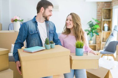 Yeni bir ev taşımak karton kutular tutarak birlikte çok mutlu genç güzel çift