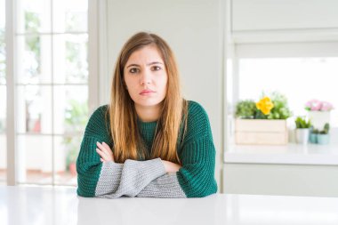 Genç güzel artı boyutu kadın rahat çizgili kazak şüpheci ve sinir, kesişmiş kolları ile yüz üzerinde onaylamayan ifade giyiyor. Negatif kişi.