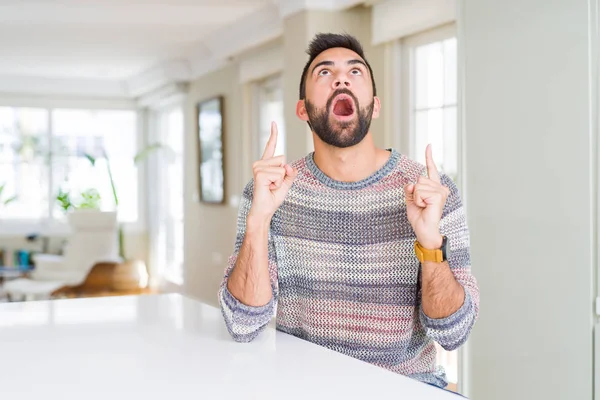 Hombre Hispano Guapo Usando Suéter Casual Casa Asombrado Sorprendido Mirando —  Fotos de Stock