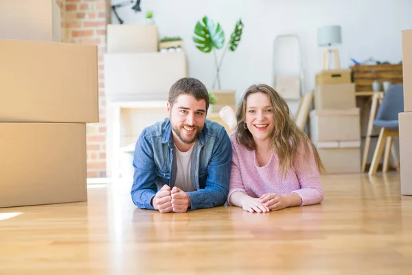 아름다운 부부는 새로운 집으로 이동주위에 골판지 상자와 바닥에 편안한 사랑에 — 스톡 사진