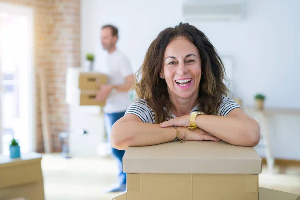Middle age senior couple moving to a new house, woman smiling happy in love with new apartment