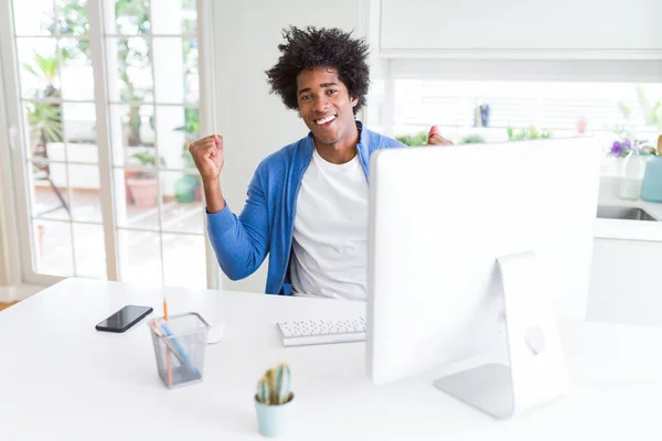 コンピュータを使って働くアフリカ系アメリカ人の男性は 腕を上げて目を開けて成功したことに驚き 驚きました 勝者のコンセプト — ストック写真