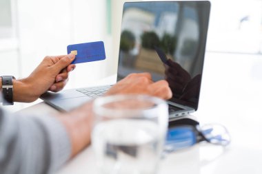 Online usin alışveriş yaparken ödeme metod olarak kredi kartı kullanan adam