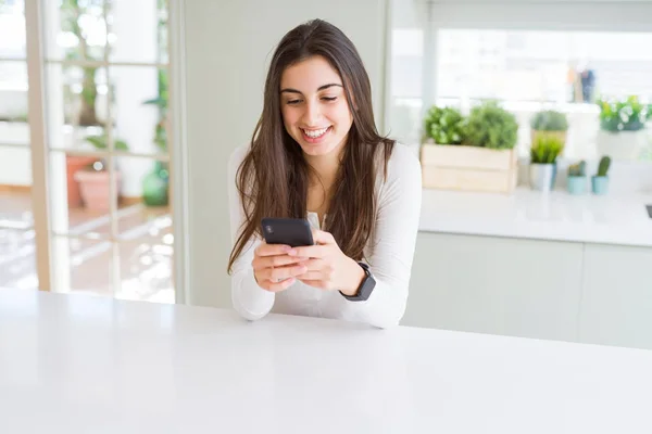 Fiatal nő használ smartphone, mosolygó boldog textil és gépelés — Stock Fotó