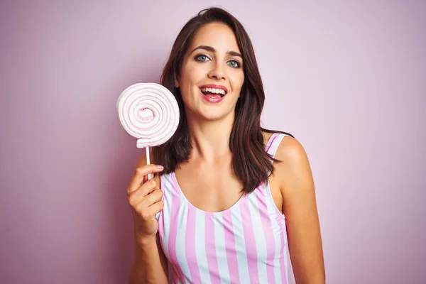 Młoda Piękna Kobieta Jedząca Słodki Cukierek Nad Różowym Białym Tle — Zdjęcie stockowe
