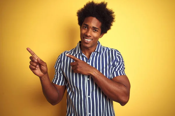 一个头发的美发美国男子站在孤立的黄色背景上 面带微笑 看着相机指着两只手和手指的一边 — 图库照片