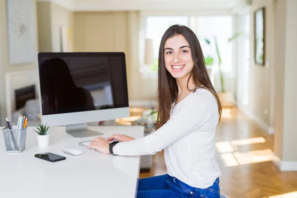Νεαρή γυναίκα χαμογελάει δουλεύοντας χρησιμοποιώντας τον υπολογιστή και δείχνοντας ένα κενό s — Φωτογραφία Αρχείου