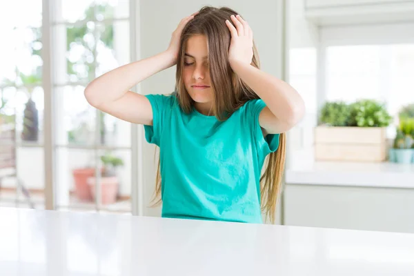 痛みと偏頭痛のために絶望的な頭痛に苦しむ緑のTシャツを着て美しい若い女の子の子供 頭の上に手を置く — ストック写真