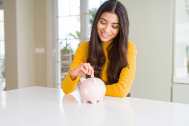 Kadın gibi Piggy banka içinde bir sikke koyarak gülümseyen yakın