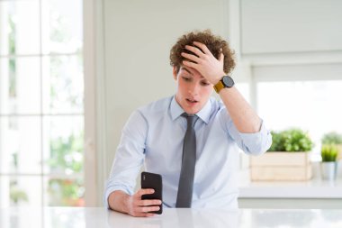 Ofiste akıllı telefon kullanarak genç iş adamı baş el ile vurguladı, utanç ve sürpriz yüz ile şok, öfkeli ve sinirli. Korku ve hata için üzgün.
