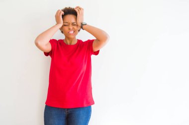 Beyaz arka plan üzerinde genç güzel afro-amerikan kadın baş ağrısı umutsuz muzdarip ve stresli çünkü ağrı ve migren. Eller baş üstünde.