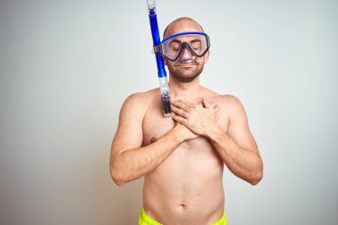 Kapalı gözler ve yüz minnettar jest ile göğsünde eller ile gülümseyen izole arka plan üzerinde donatılan Dalış Şnorkel giyen genç adam. Sağlık konsepti.