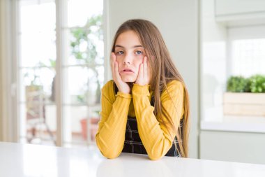 Evde rahat sarı kazak giyen genç güzel sarışın çocuk kız yorgun eller yüz, depresyon ve üzüntü kapsayan, üzgün ve sorun için tahriş