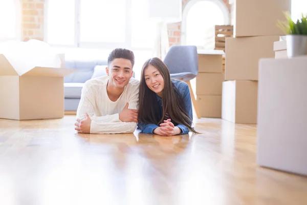 Joven pareja asiática acostada en el suelo de la nueva casa arround cardb — Foto de Stock