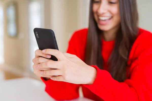 Jovem mulher usando smartphone, sorrindo mensagens de texto felizes e digitação — Fotografia de Stock