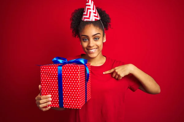 Afro Amerikaanse Vrouw Dragen Grappige Hoed Holding Verjaardagsgift Geïsoleerde Rode — Stockfoto