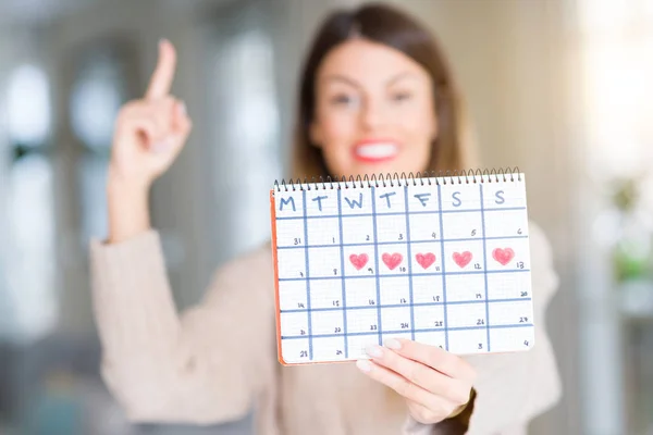 Young Beautiful Woman Holding Menstruation Calendar Home Surprised Idea Question — Stock Photo, Image