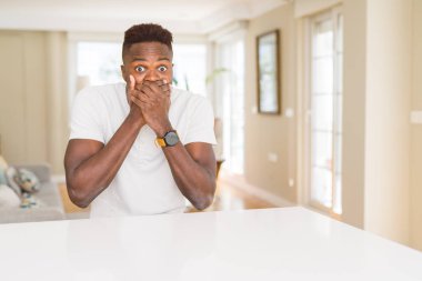 Afro-Amerikan yakışıklı beyaz tablo evde kapsayan ağız elle hata için şok. Gizli kavramı.