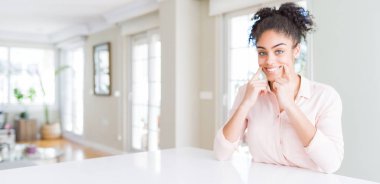 Afro saç ile güzel Afrikalı Amerikan kadın geniş açı açık ağız ile gülümseyen, parmaklar işaret ve neşeli gülümseme zorlamak