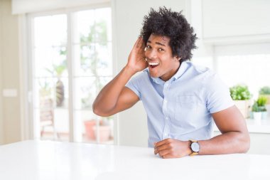 Afrikalı Amerikan iş adamı kulak üzerine el ile gülümseyen söylenti veya dedikodu bir işitme dinlerken. Sağırlık konsepti.