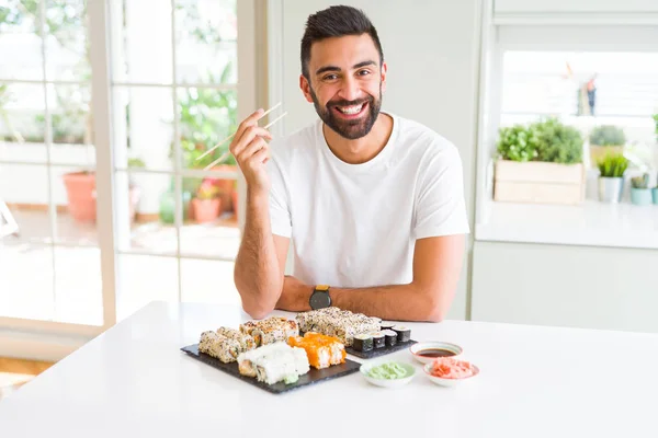 Przystojny Hiszpan Jedzenia Asian Sushi Pomocą Pałeczek Szczęśliwą Twarzą Stojący — Zdjęcie stockowe
