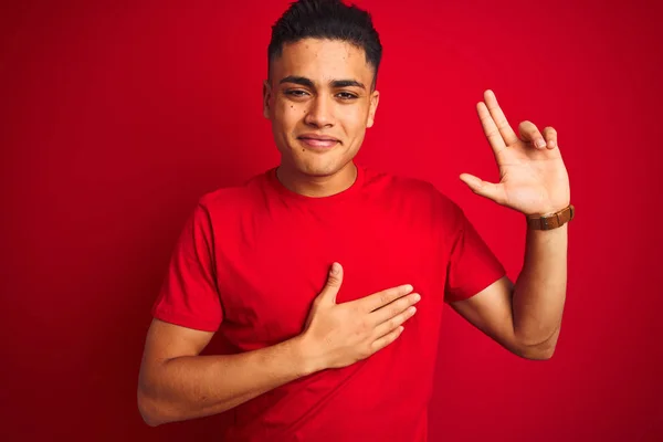 Jovem Brasileiro Vestindo Camiseta Sobre Fundo Vermelho Isolado Sorrindo Jurando — Fotografia de Stock