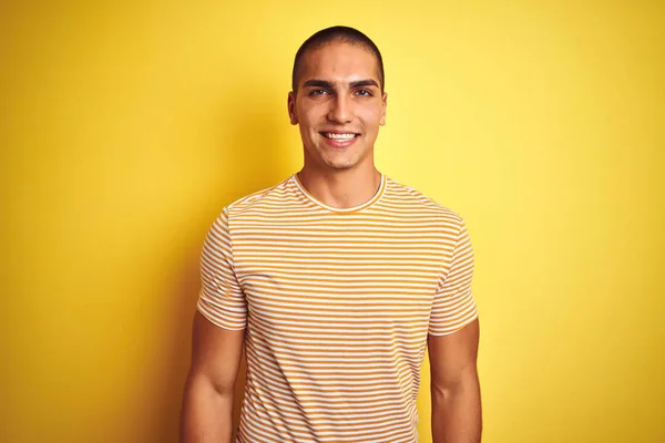 年轻的帅哥穿着条纹T恤 在黄色的孤立背景与快乐和冷静的笑容在脸上 幸运的人 — 图库照片
