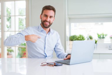 Sürpriz yüz kendisini işaret parmak ile bilgisayar laptop kullanarak çalışan yakışıklı iş adam