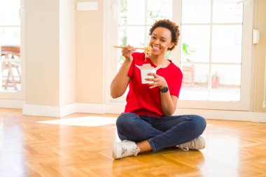 Güzel genç Afro-Amerikan kadın Choo kullanarak .erişte yiyorlar
