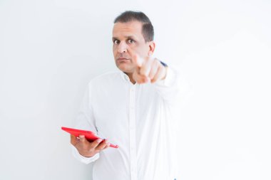 Orta yaş adam beyaz duvar üzerinde dijital tablo kullanarak kamera ve size parmak ile işaret, el işareti, ön pozitif ve emin jest