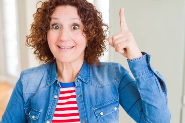 Güzel kıdemli kadın başarılı bir fikir ile parmak yukarı işaret. Çıkıldı ve mutlu. Bir numara.