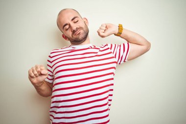 Beyaz izole arka plan, yorgun ve rahat, Uykulu ve erken sabah için esneme üzerinde rahat çizgili kırmızı t-shirt giyen sakal ile genç kel adam