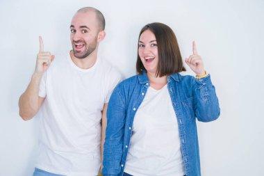 Genç çift birlikte beyaz izole arka planda başarılı bir fikir parmak yukarı işaret. Çıkıldı ve mutlu. Bir numara.