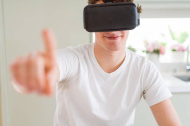 Genç adam eğleniyor evde sanal gerçeklik gözlüklü