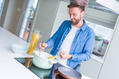 Evde makarna pişiren yakışıklı adam.