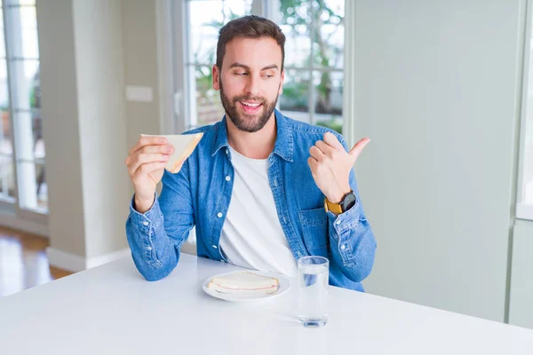 Hombre Guapo Comiendo Sándwich Saludable Señalando Mostrando Con Pulgar Hacia — Foto de Stock