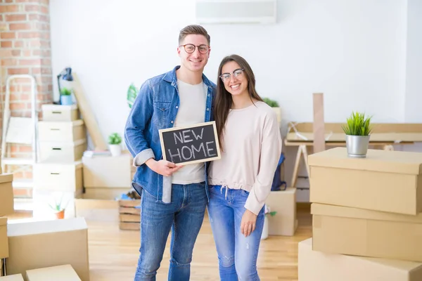 Hermosa pareja joven abrazándose en el amor y sosteniendo la pizarra mo — Foto de Stock