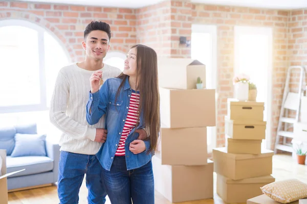 Junges asiatisches Paar hält Schlüssel für neues Haus, lächelt glücklich und — Stockfoto
