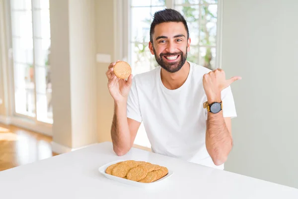 Όμορφος Ισπανικός Άνθρωπος Που Τρώει Υγιή Ολόκληρα Μπισκότα Δημητριακών Δείχνοντας — Φωτογραφία Αρχείου