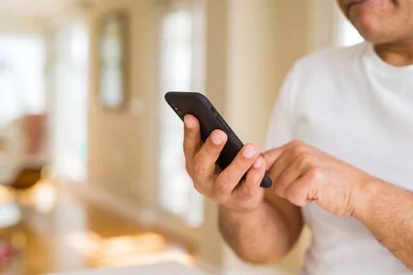 Fechar as mãos homem de meia idade usando smartphone em casa — Fotografia de Stock