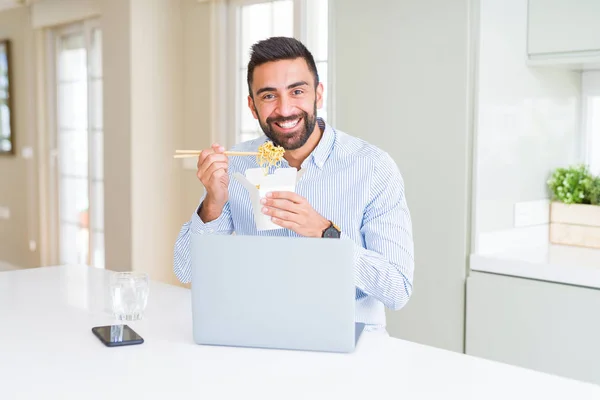 Business man eating asian food from delivery while working using