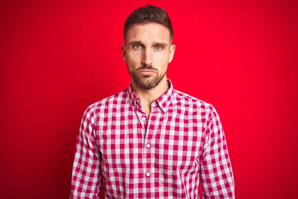Kırmızı izole arka plan üzerinde genç yakışıklı adam depresif ve sıkıntı için endişe, ağlayan öfkeli ve korkuyor. Üzücü ifade.