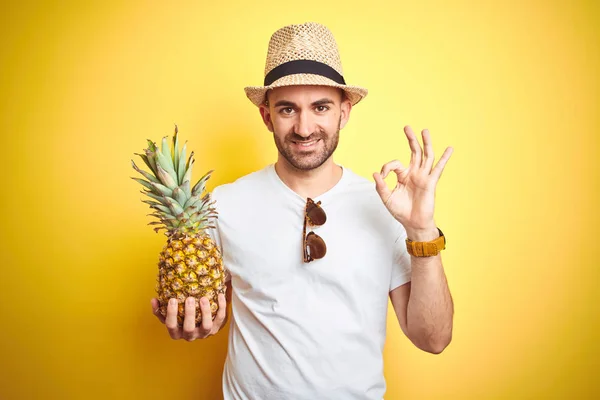 Homem Jovem Usando Chapéu Verão Segurando Abacaxi Sobre Fundo Amarelo — Fotografia de Stock