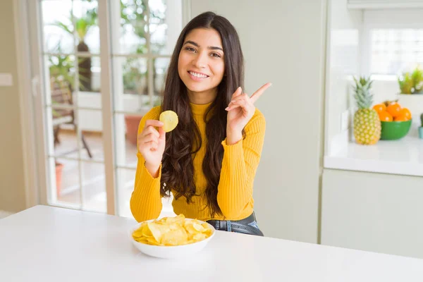 ファーストフードポテトチップスを食べる若い女性は 手と指を横に指差して非常に幸せ — ストック写真