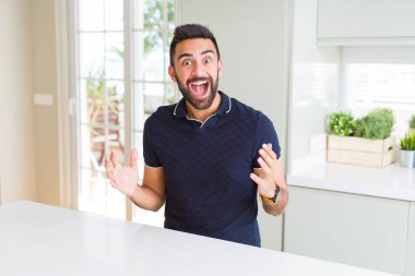 Evde yakışıklı İspanyol adam deli kutluyor ve silah ile başarı için hayran kaldırdı ve açık gözleri heyecanlı çığlık. Kazanan kavramı